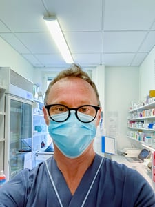Selfie eines Doktors mit Maske im Behandlungszimmer