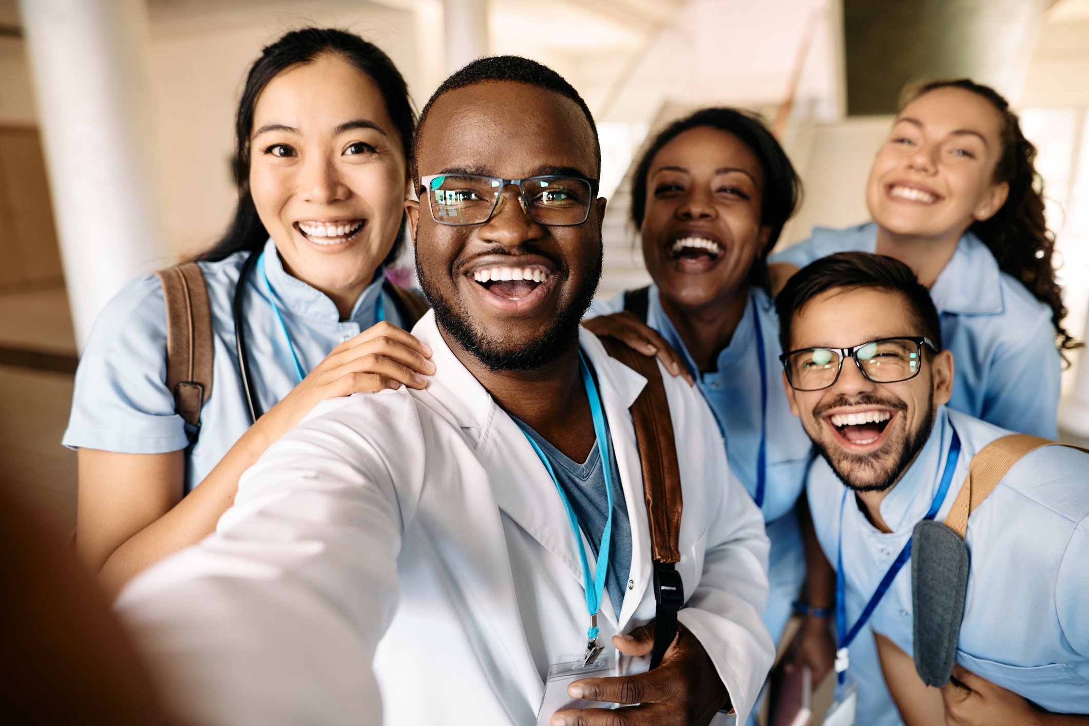 vier Ärzte und Ärztinnen nehmen ein Selfie auf und lächeln dabei in die Kamera