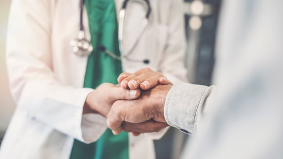 Health-worker-holding-patients-hand-1021670950_1369x770