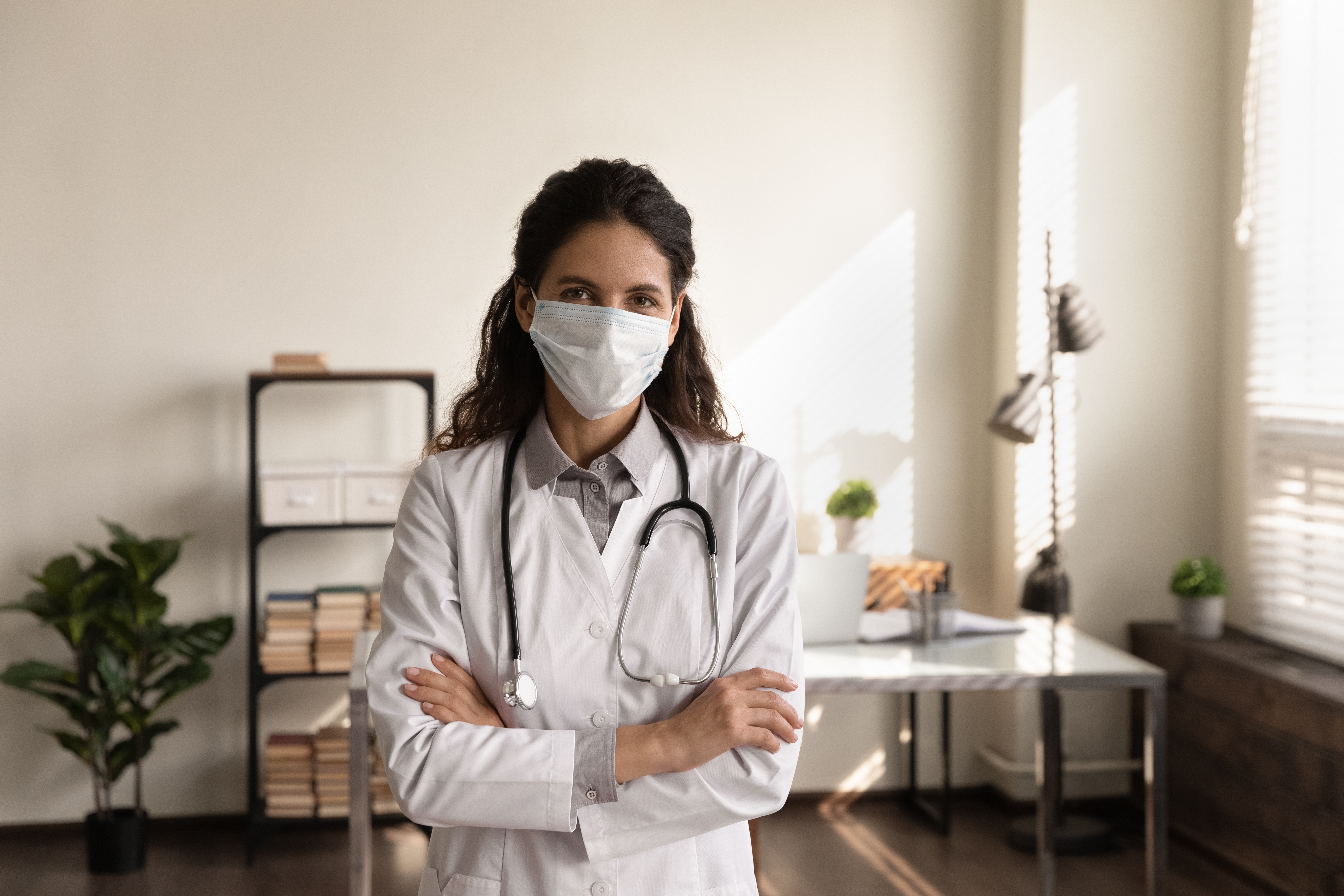 Portrait-professional-female-doctor-wearing-medical-mask-standing-in-office-1305333580_6663x4442